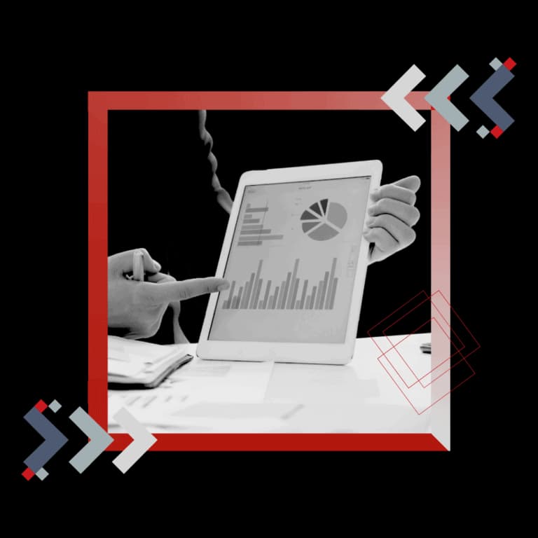 Manos revisando gráficas de venta en una tableta, enmarcadas en rojo